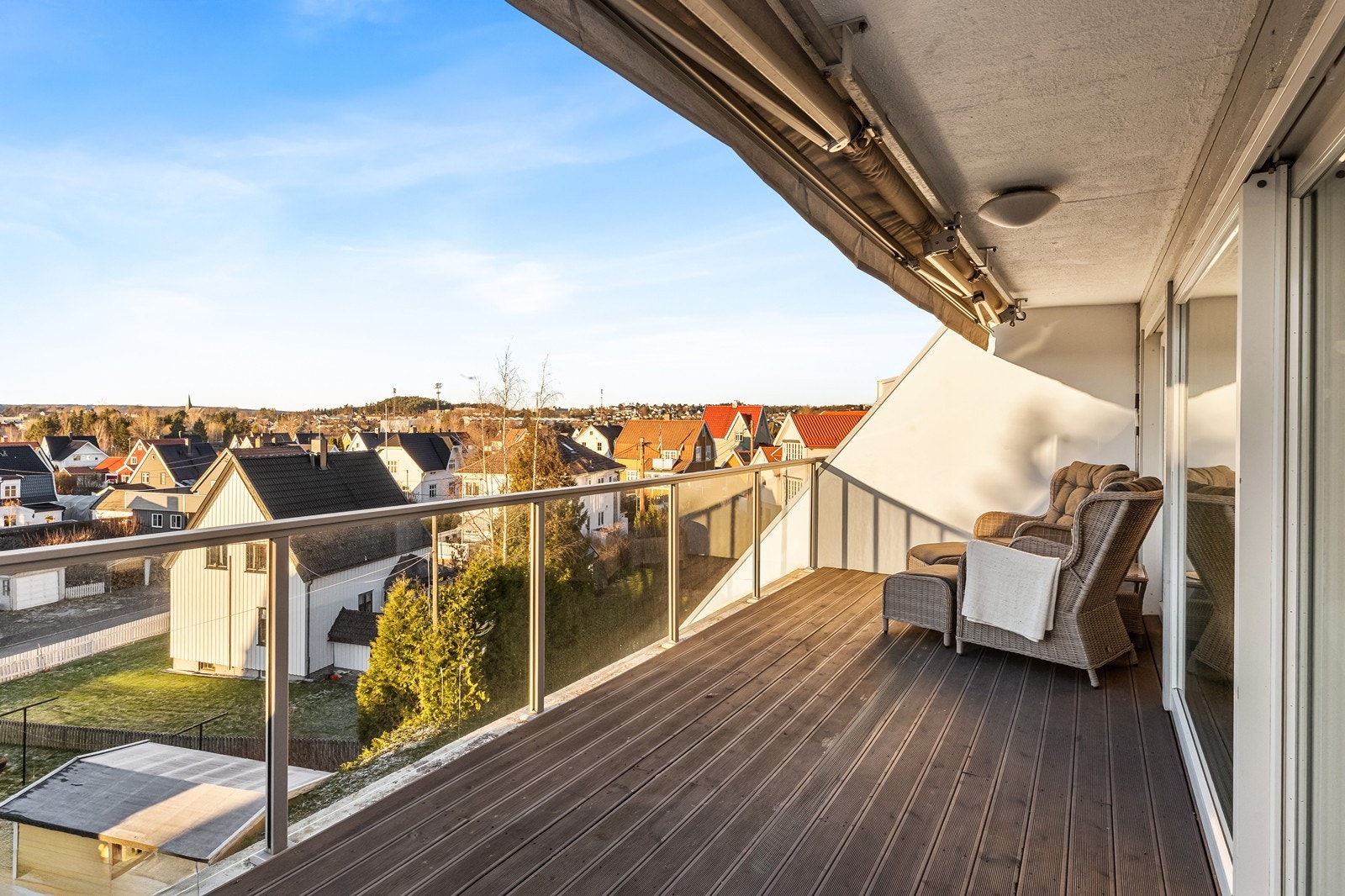 Glassrekkverk gir sikkerhet og utsyn fra den vestvendte balkongen med tregulv. Galleribilde