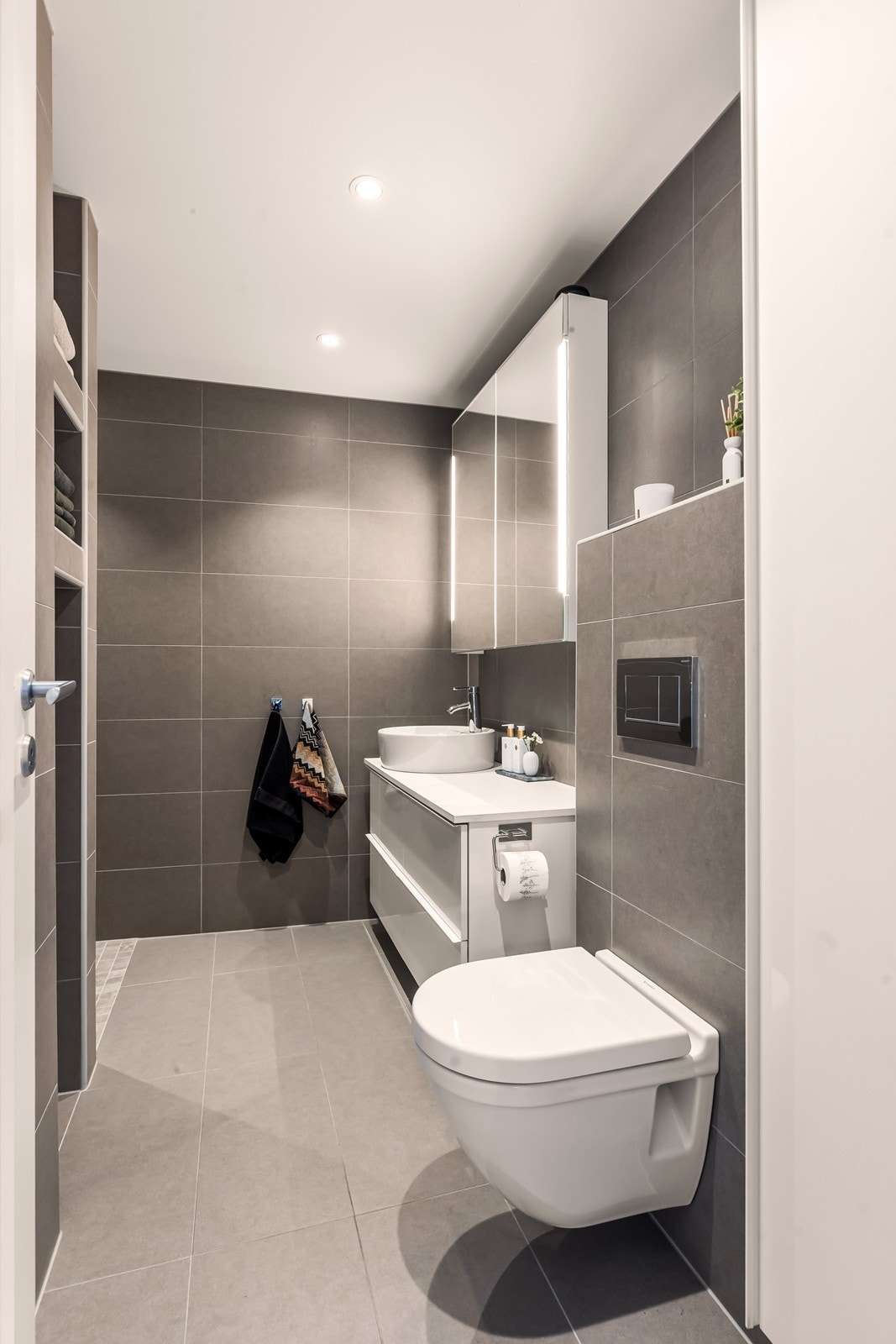 Vegghengt klosett og servant med speilskap gir effektiv plassutnyttelse. Galleribilde