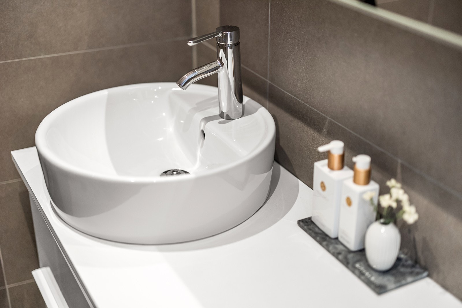 Rund servant med krom armatur gir et stilrent uttrykk. Galleribilde