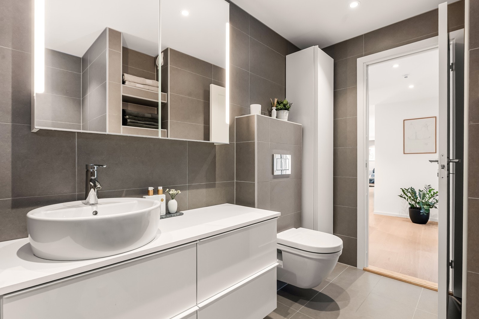 Flislagte vegger og gulv med elektriske varmekabler gir et moderne bademiljø. Galleribilde