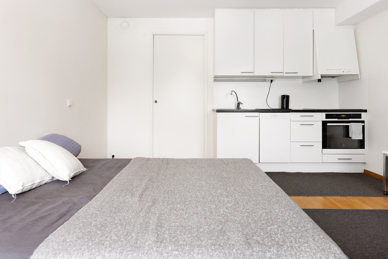 Kjøkkeninnredningen har glatte, hvite fronter og en mørk laminatbenkeplate. Galleribilde