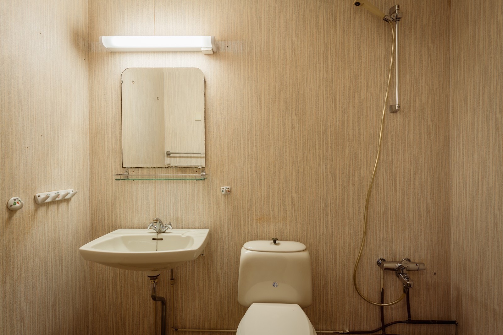 På badet er det enkel vaskeservant, gulvmontert wc og dusjhjørne. Galleribilde