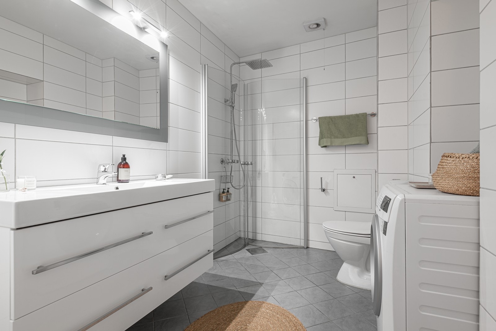 Stort tidløst bad fra 2013 med flislagt gulv og vegger med malt overflate i himling. Opplegg for vaskemaskin Galleribilde