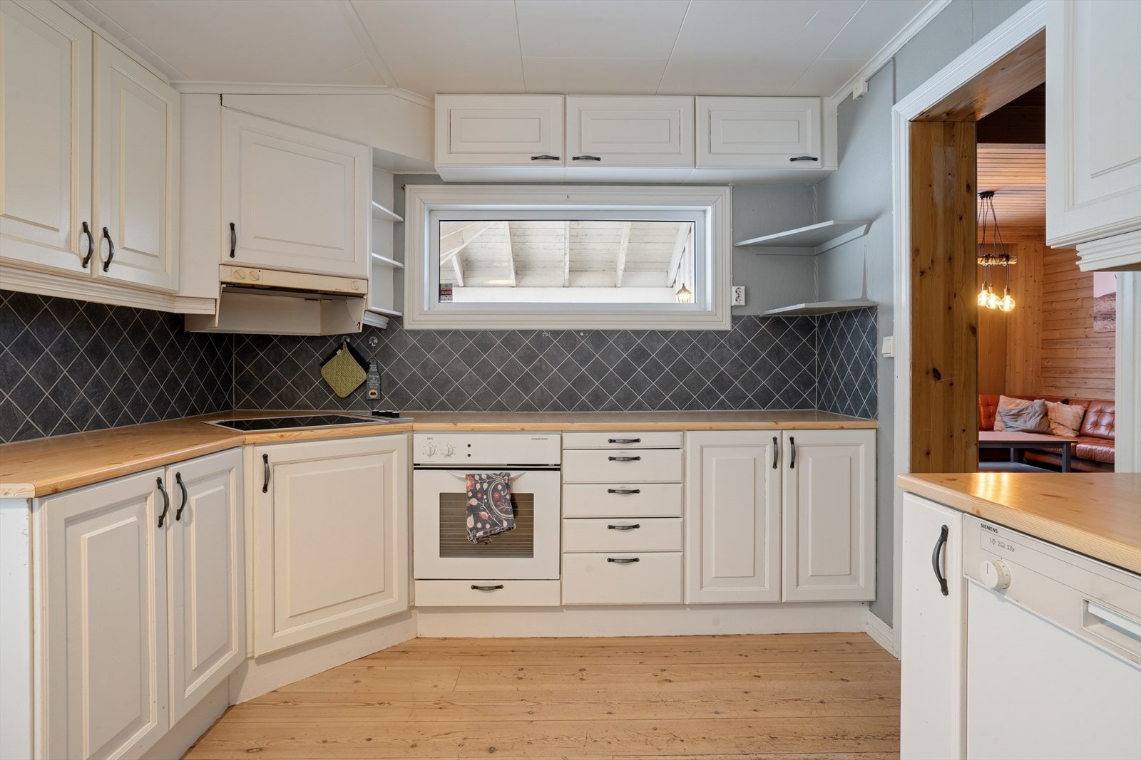 Kjøkken med malt heltre innredning antatt fra 1996. Integrert platetopp og stekeovn. Galleribilde