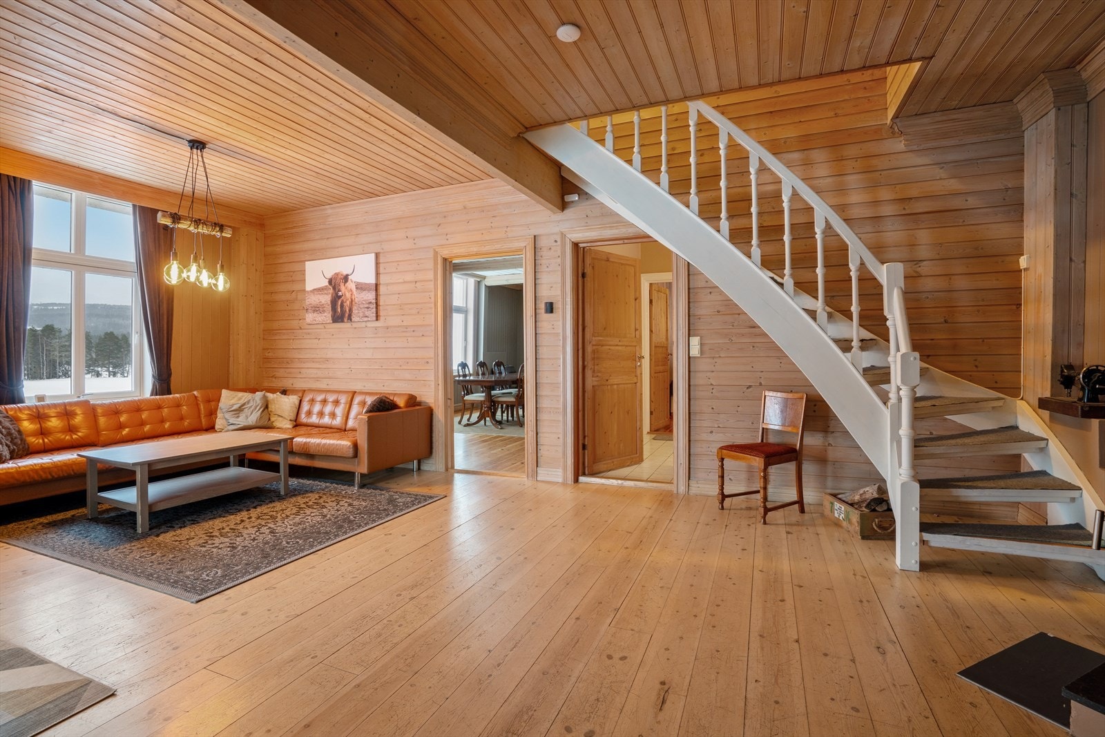 Romslig dagligstue innenfor spisestuen og kjøkkenet. Dør under trappen leder til bad og soverommet i 1. etasje. Galleribilde