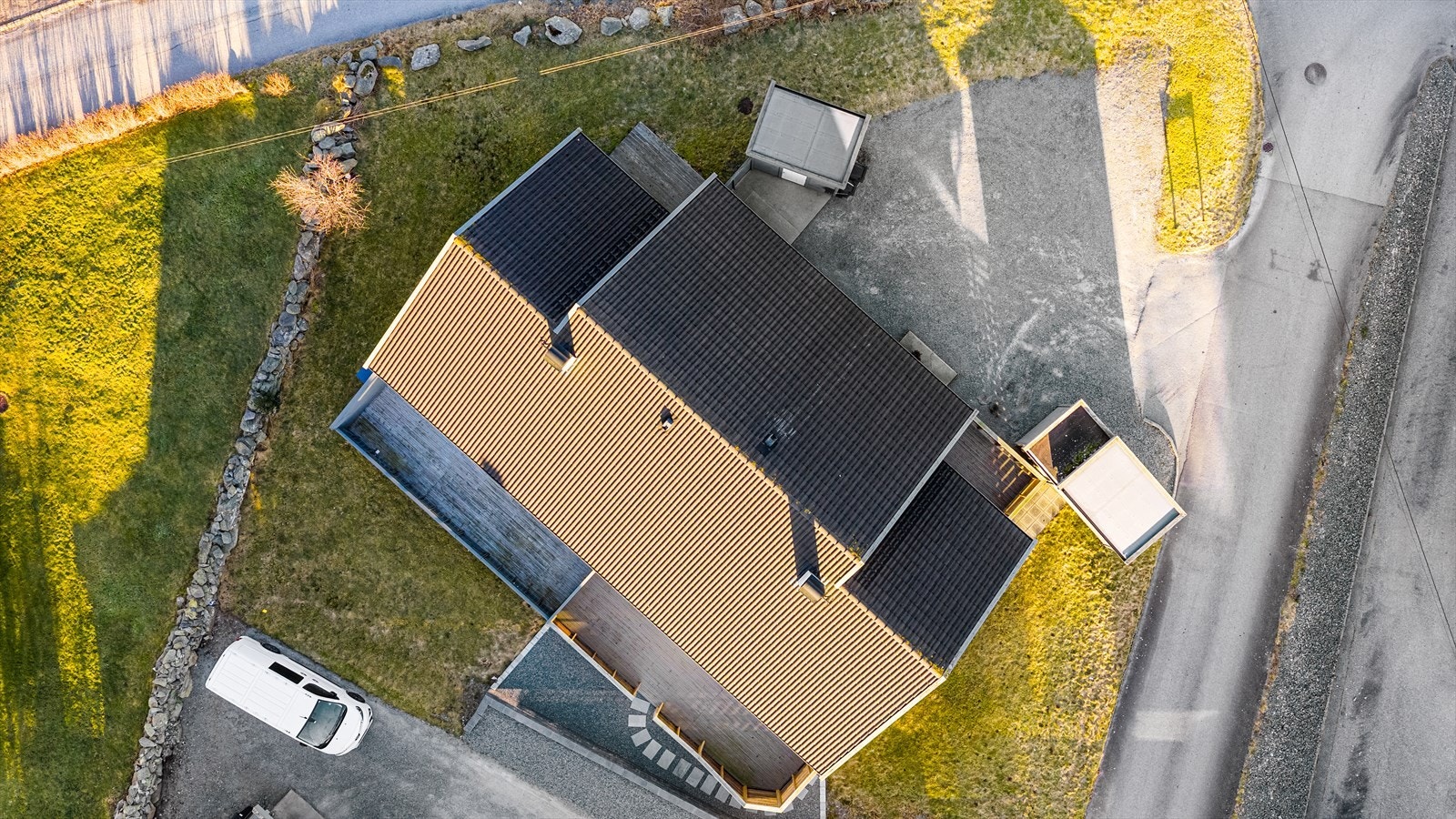 Sameiet har en felles eiet tomt som er opparbeidet med gruset gårdsrom, plen og noe beplantning Galleribilde