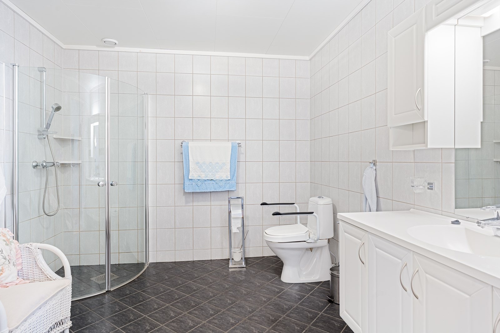 Lys og romslig bad med fliser på gulv og vegger - gulvet er utstyrt med elektriske varmekabler Galleribilde