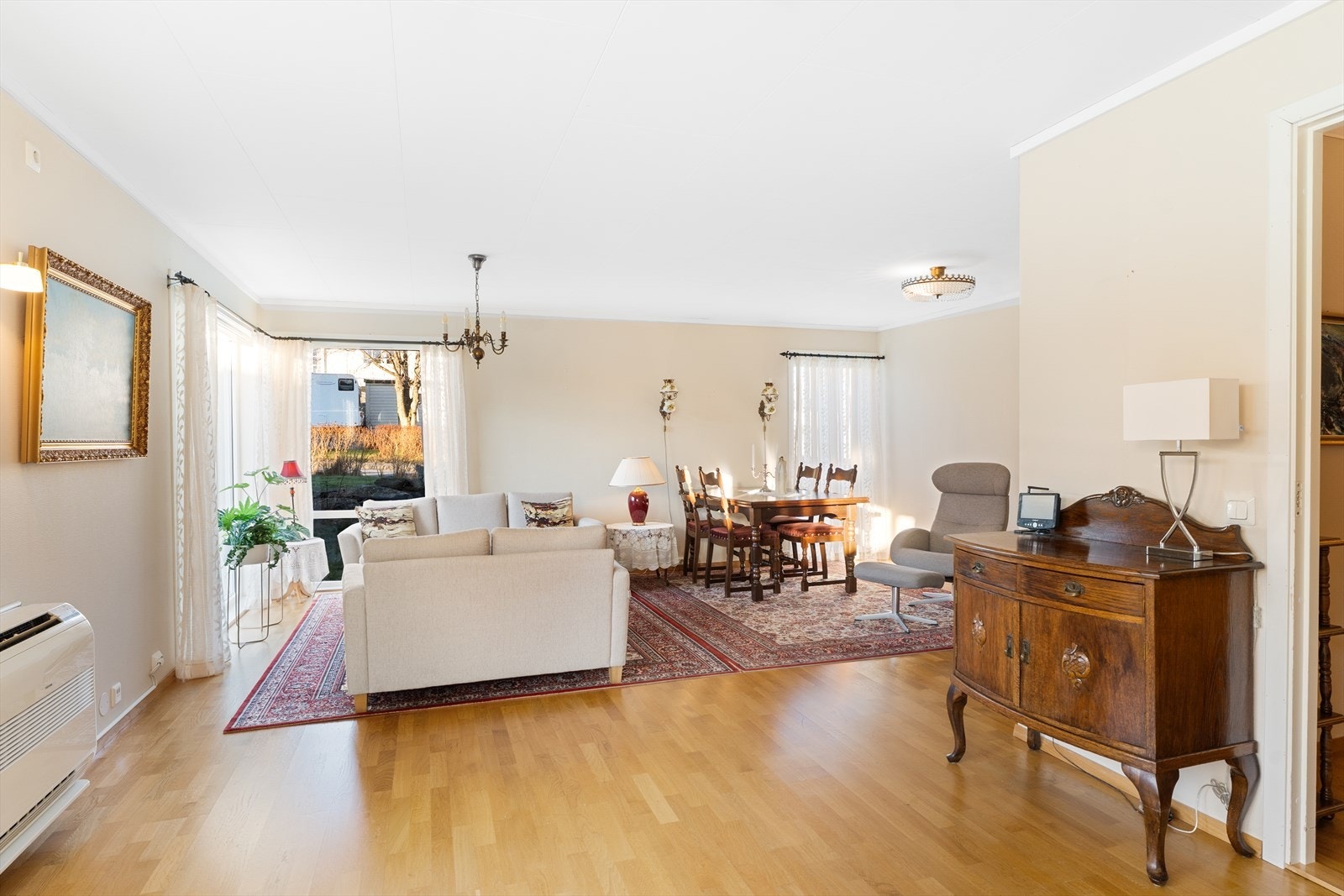 Boligen har en lys og romslig stue med åpen løsning mot kjøkkenet Galleribilde