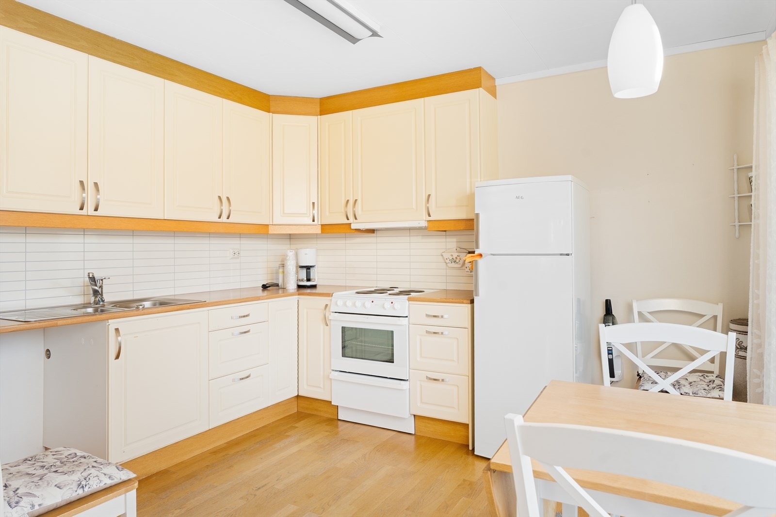 Kjøkkenet har flott kjøkkeninnredning fra Ballingslöv med hvite, profilerte fronter og laminat benkeplate Galleribilde