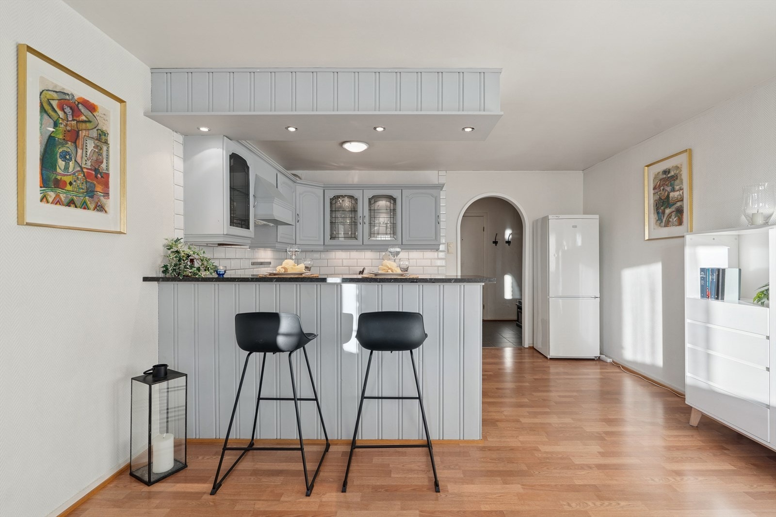 Tidligere vegg mellom kjøkken og stue er fjernet og erstattet med en halvøy med innredning på kjøkkensiden og spiseplasser på stuesiden Galleribilde