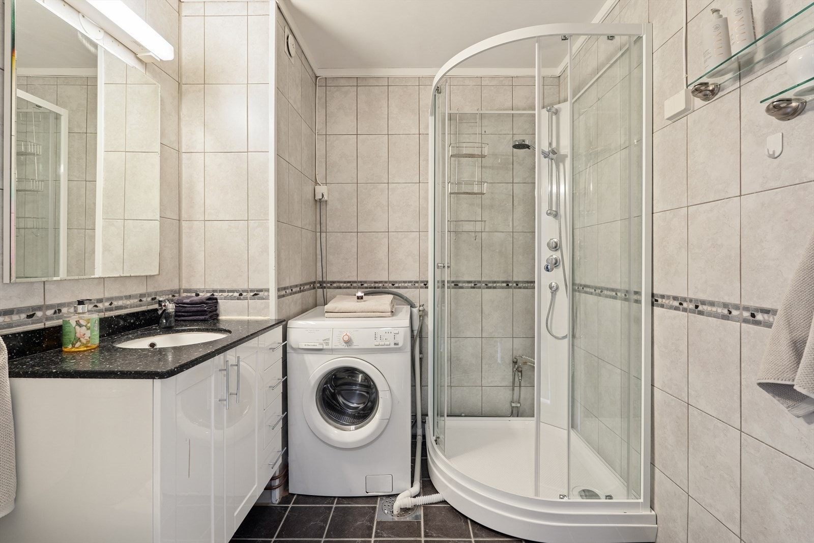 Baderommet er oppusset etter byggeår og har fliser på gulv og vegger - et tidligere badekar ble fjernet og dusjkabinett installert Galleribilde