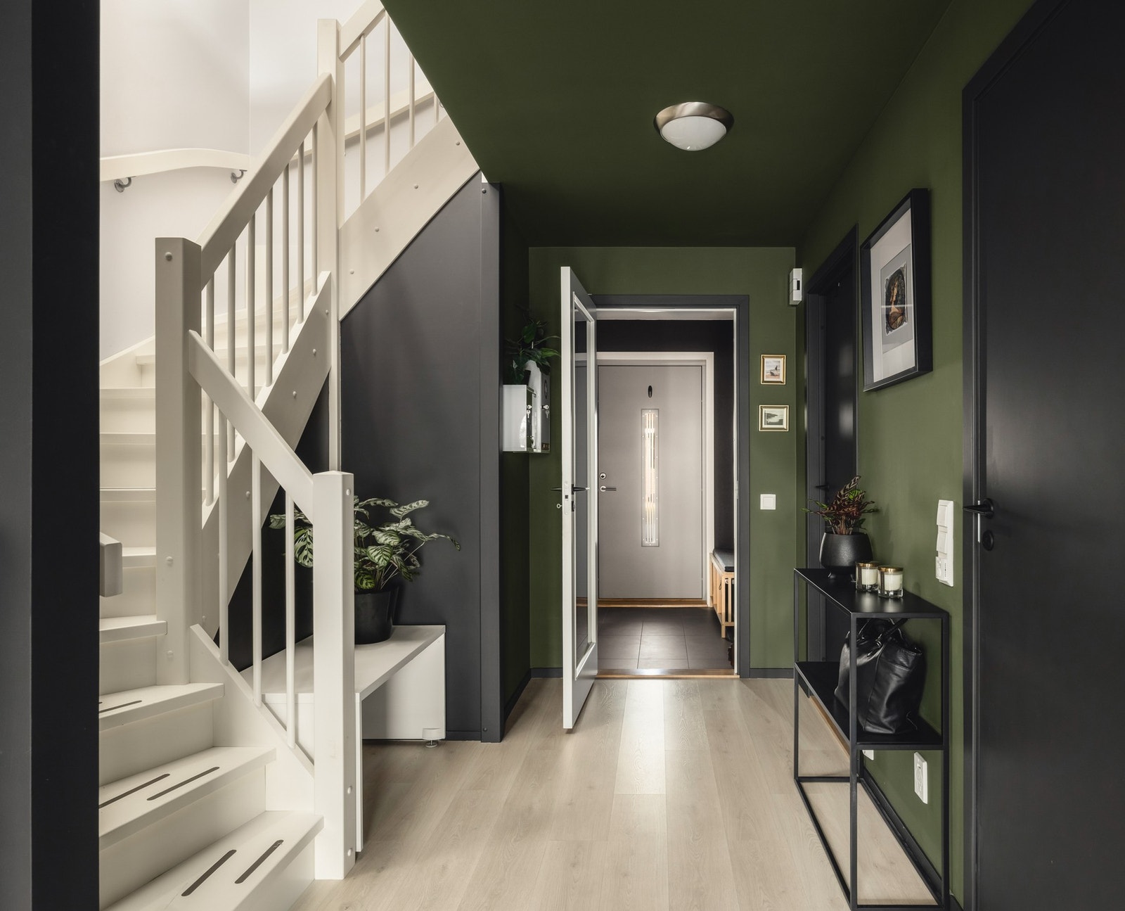 Entré med trapp til andre etasje, grønne vegger og lys parkett. Galleribilde