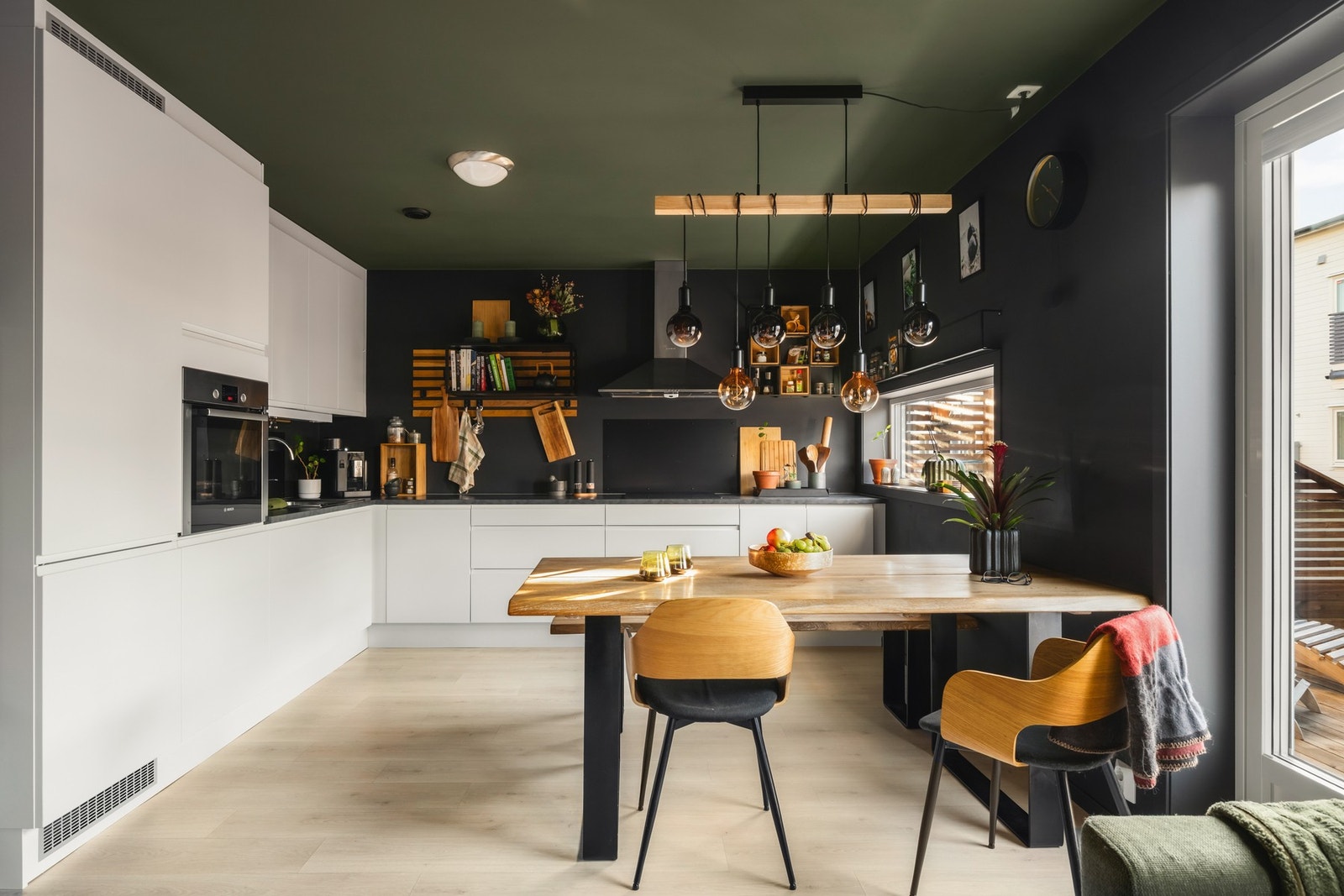 Moderne kjøkken med stilfull belysning, praktisk innredning og god plass til matlaging og måltider. Galleribilde