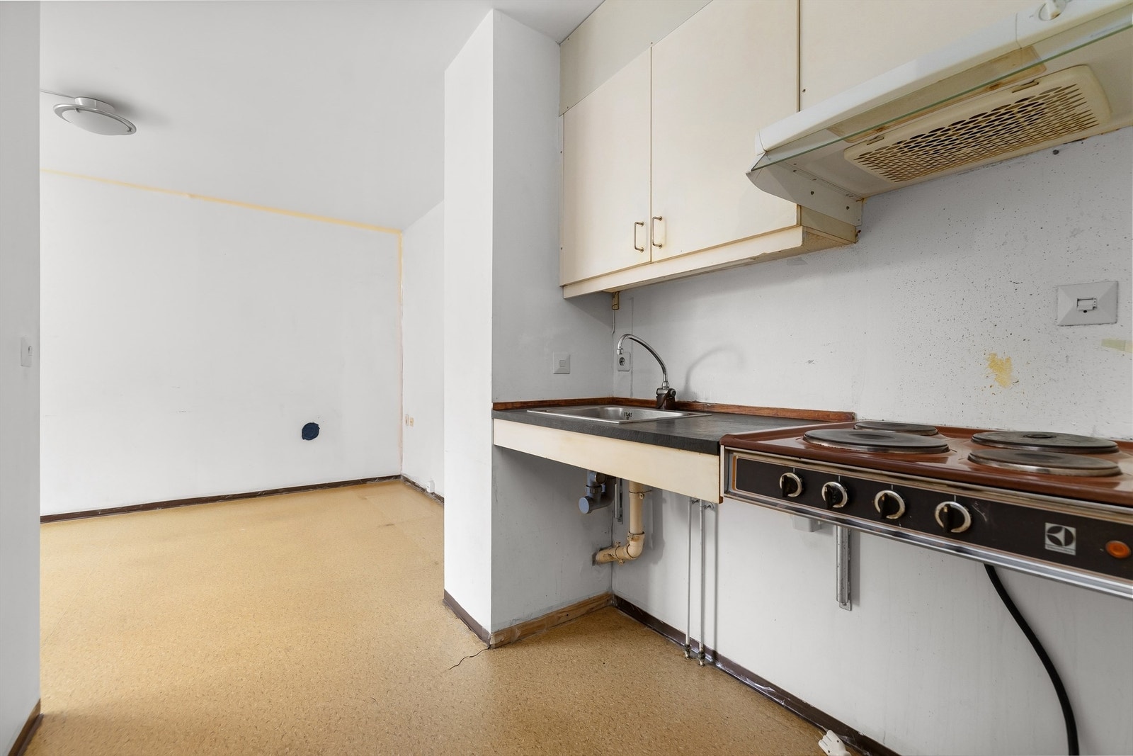 Slette fronter, laminat benkeplate samt nedfelt oppvaskkum i rustfritt stål med ett-greps blandebatteri. I tillegg har kjøkkenet stikkontakt på vegg over kjøkkenbenk og kokeplate. Ventilator tilkoblet avtrekk er plassert i overskap. Galleribilde