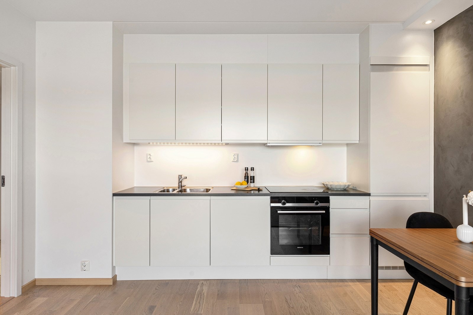 Innredningen består av både over- og underskap, med belysning under overskap, og malt flate mellom benkeplate og overskap. Galleribilde