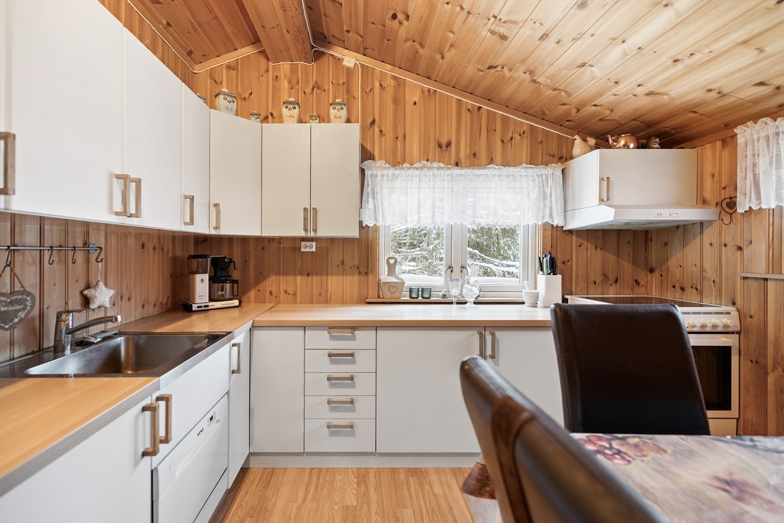 Kjøkkeninnredning med hvite, glatte fronter og godt med skap- og benkeplass. Galleribilde