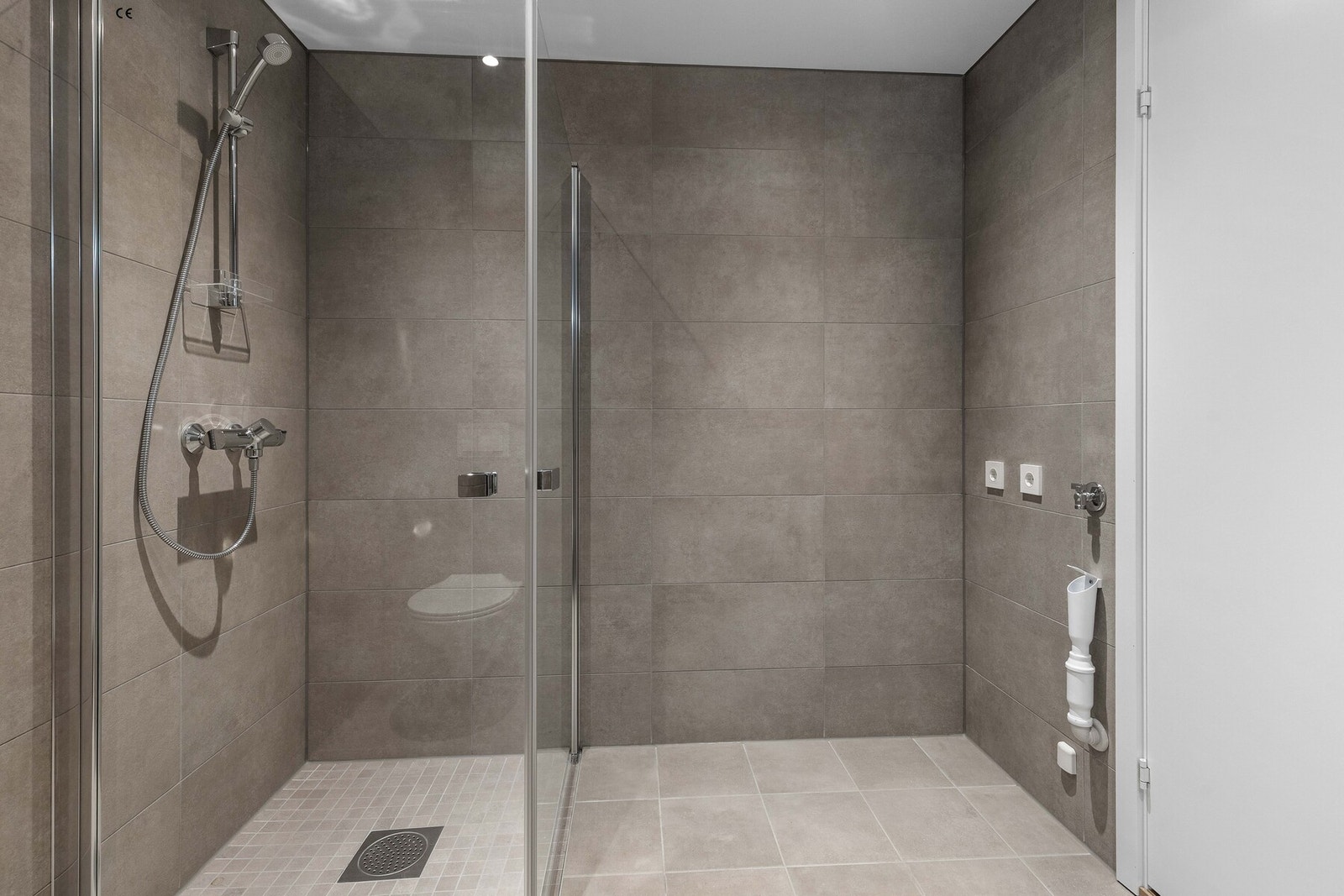 Det er opplegg for både vaskemaskin og tørketrommel. Dusjsonen har innfellbare glassvegger i klart glass. Galleribilde