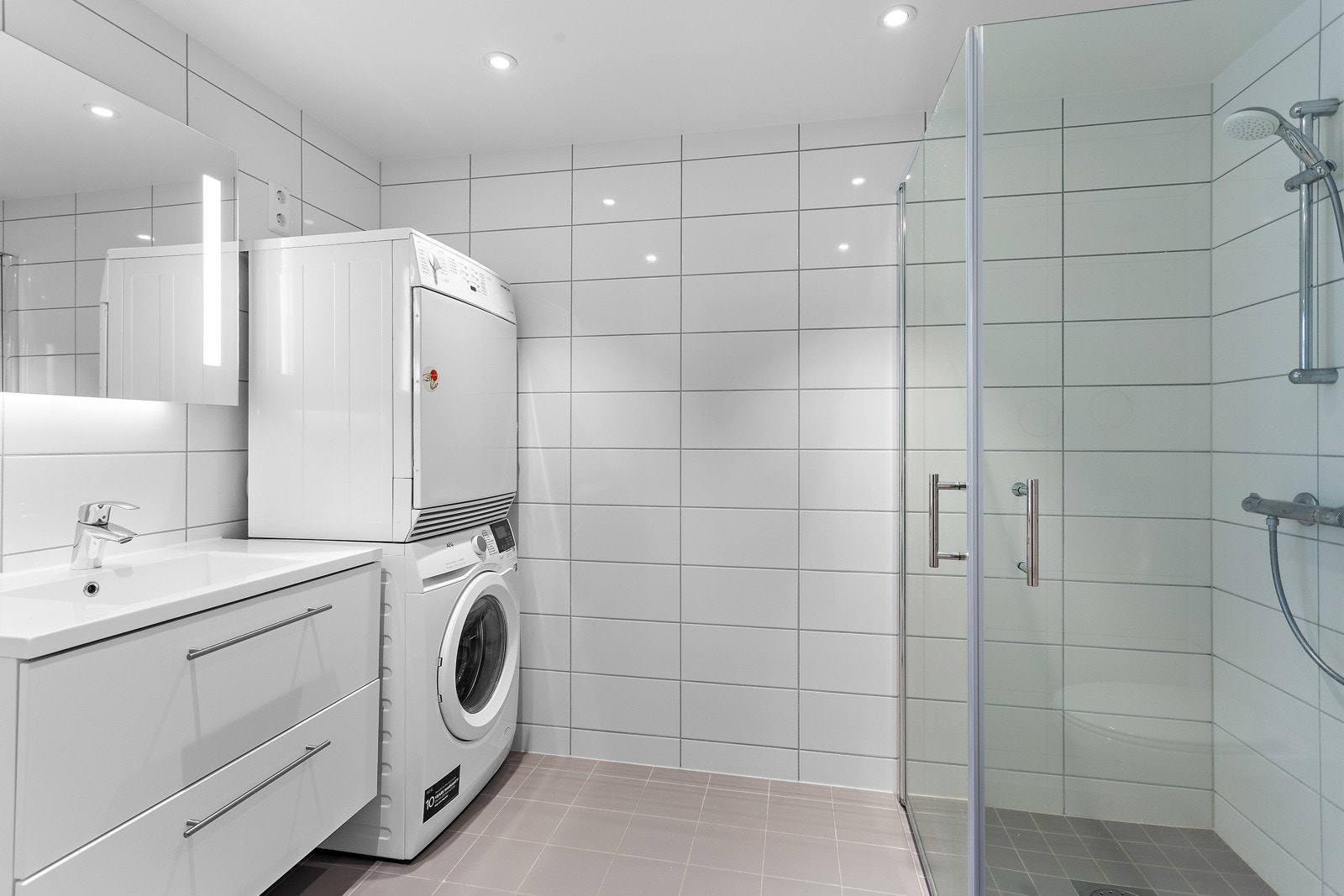 Flislagt bad med varme i gulvet og opplegg for vask/tørk som kan plasseres i høyden. Galleribilde