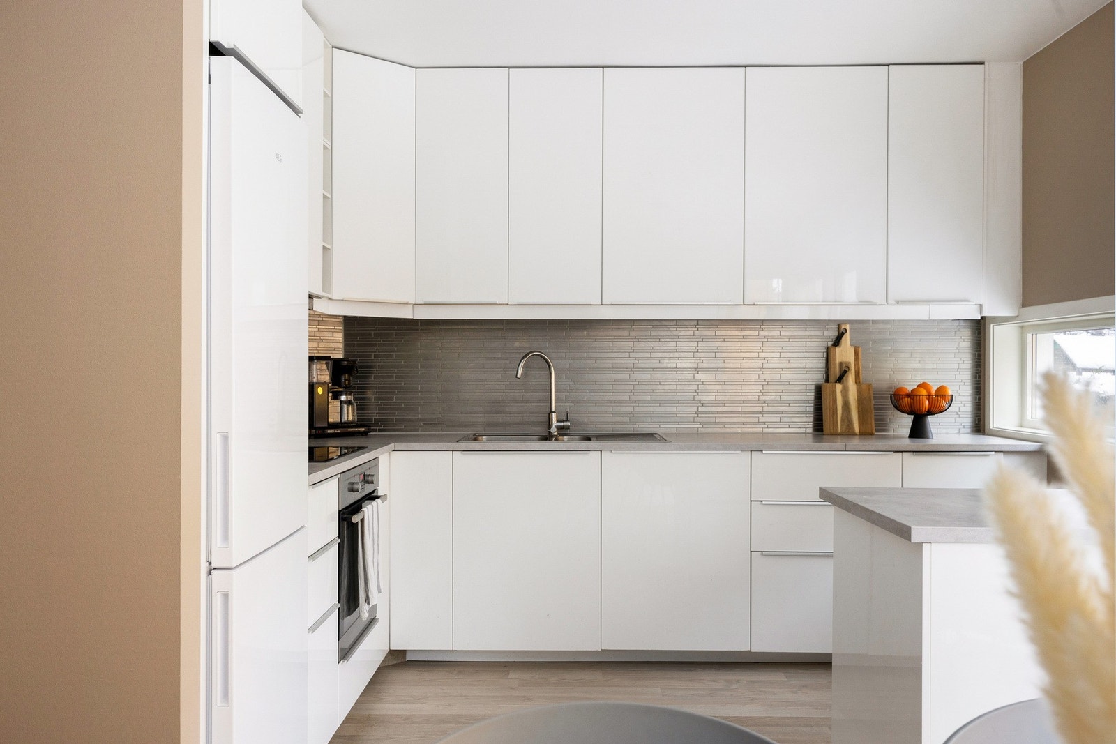 Pen kjøkkeninnredning med glatte fronter fra IKEA. Det er laminat benkeplate med nedfelt kum. Galleribilde