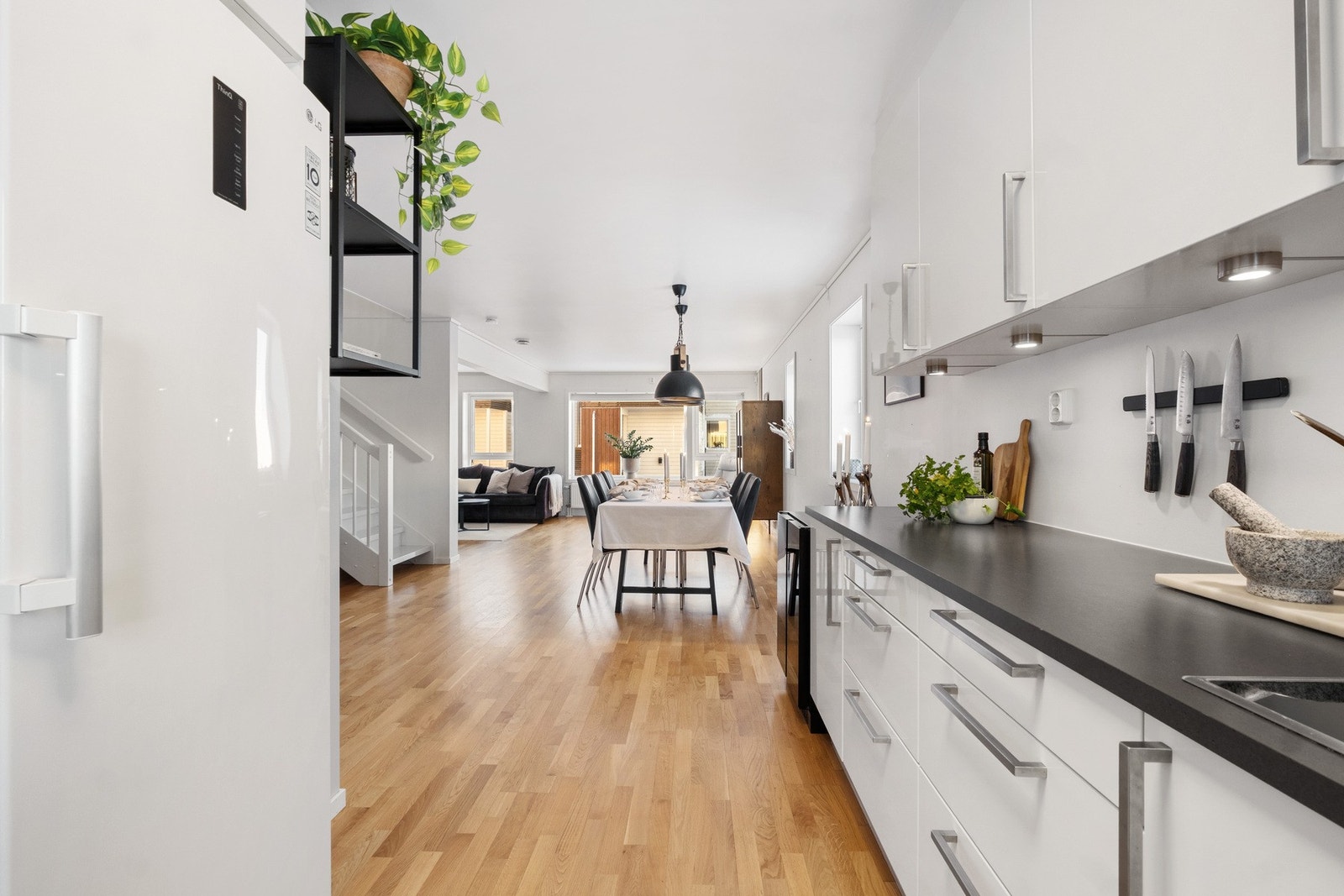 Her er det integrerte hvitevarer som oppvaskmaskin, stekeovn og induksjonstopp, med frittstående kjøleskap. Galleribilde