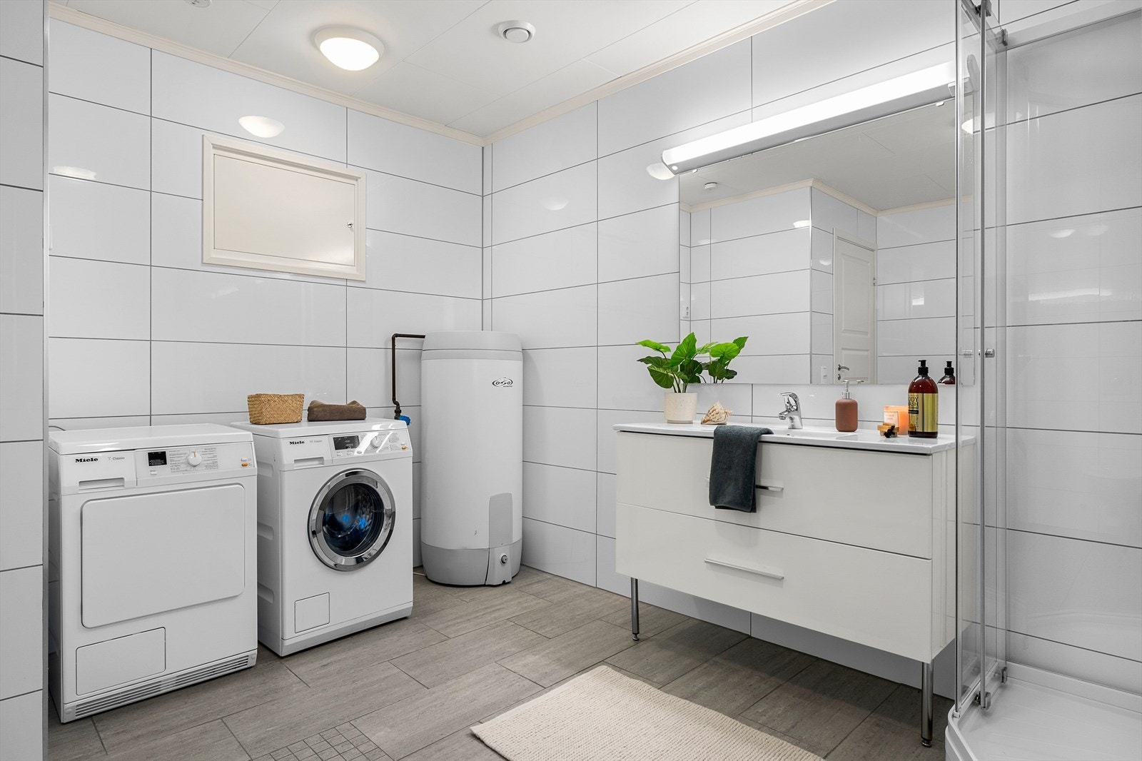 Badet har fått TG1 av takstmann og er innredet med dusjkabinett, veggmontert toalett, innredning med servant og opplegg for vaskemaskin (Kran og avløp). Galleribilde