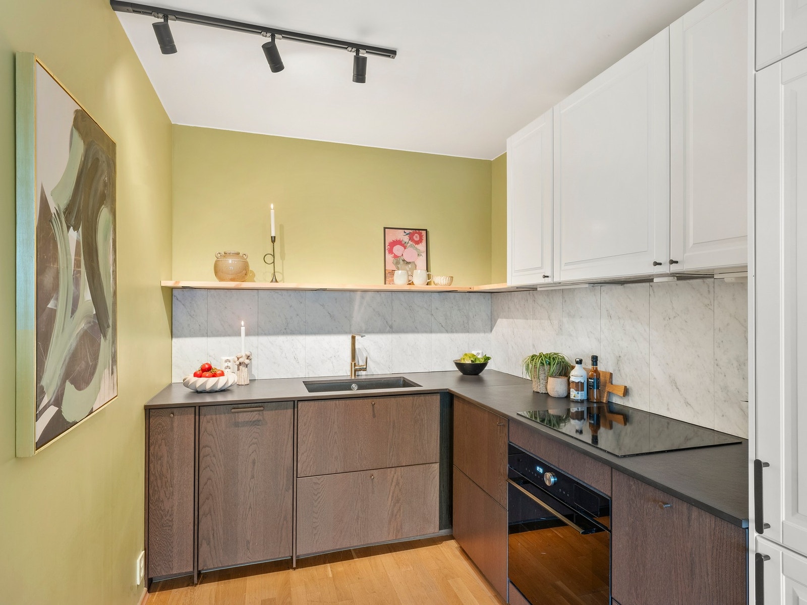 Kjøkkenet byr på rikelig oppbevaringsplass i under og overskap Galleribilde