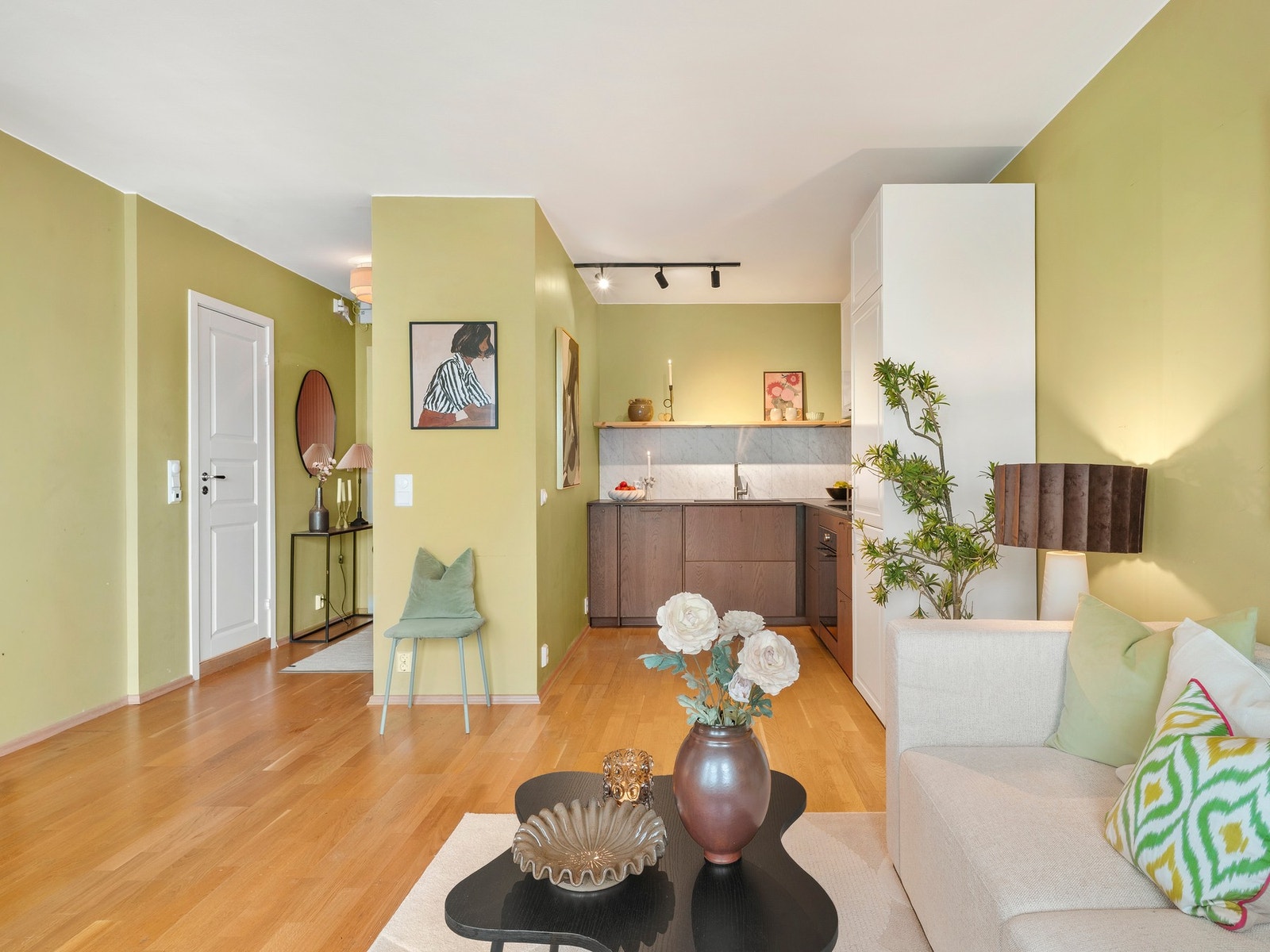 Det er åpen løsning mellom stue og kjøkken, som bidrar til en luftig og sosial atmosfære Galleribilde