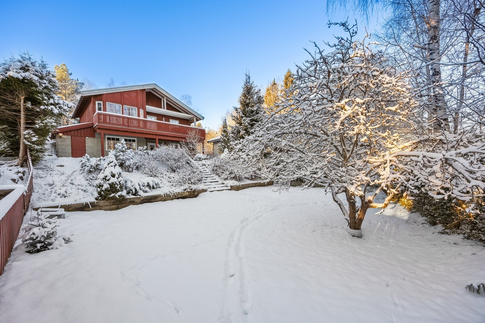 Boligen har solrike terrasser og en frodig hage med plen, frukttrær, hekk og prydbusker. Galleribilde