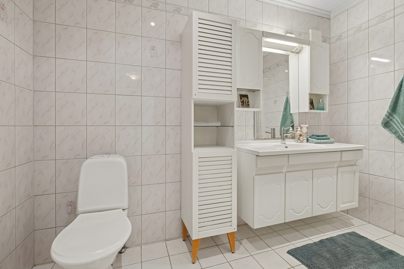 Badet er utstyrt med dusjhjørne, toalett og baderomsinnredning. Galleribilde