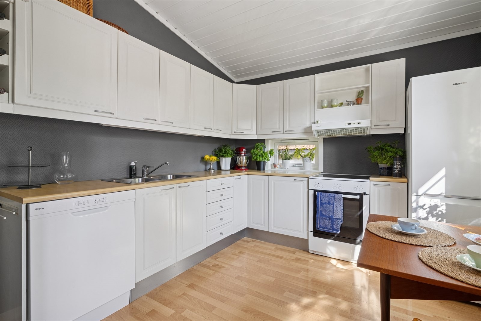 Vinklet innredning med plass i innredningen til frittstående hvitevarer. Disse medfølger. Galleribilde