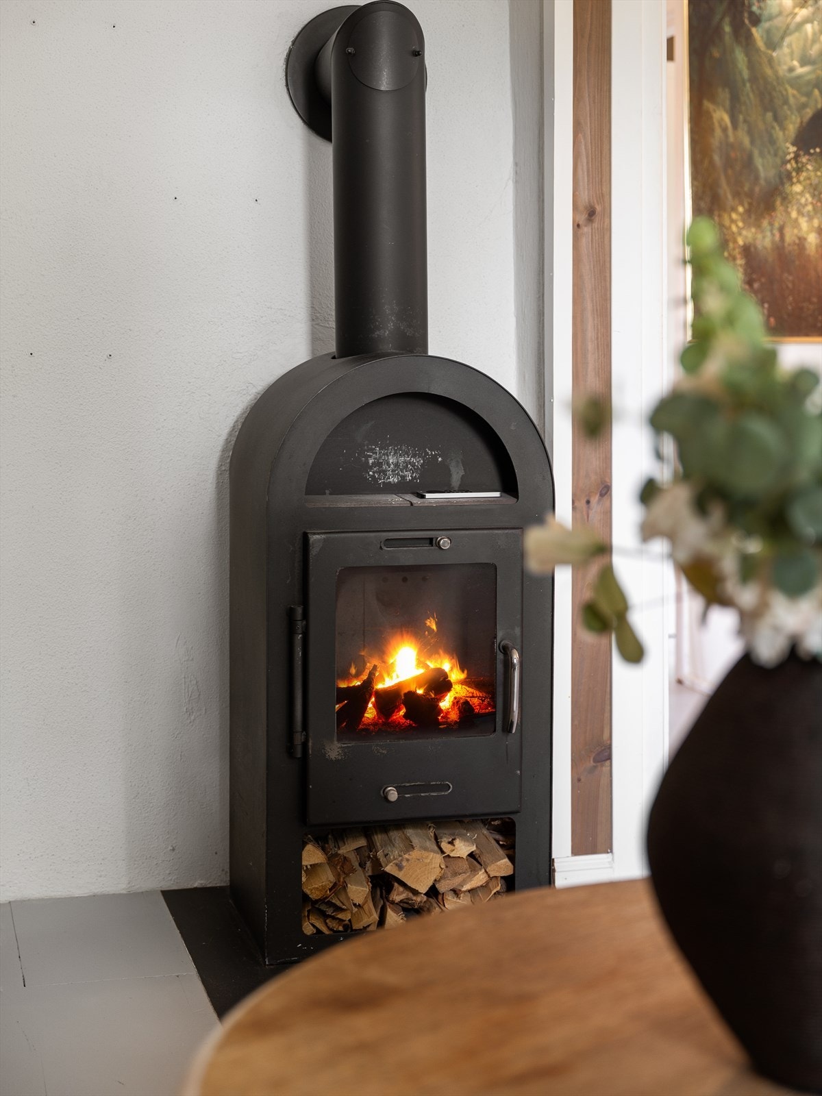 Som et fint midtpunkt av stuen har du en moderne vedovn som varmer godt på kalde høst- og vinterdager, samt bidrar til hygge. Galleribilde