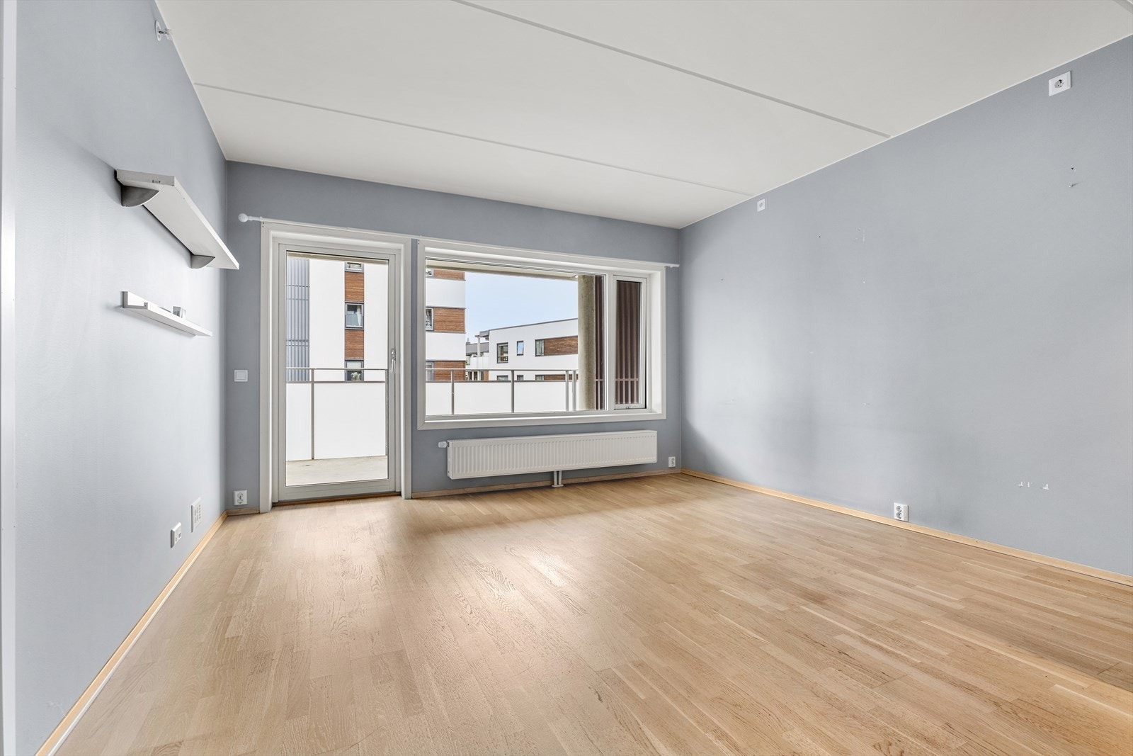 Lys stue med gjennomgående parkett og direkte utgang til en herlig balkong. Galleribilde