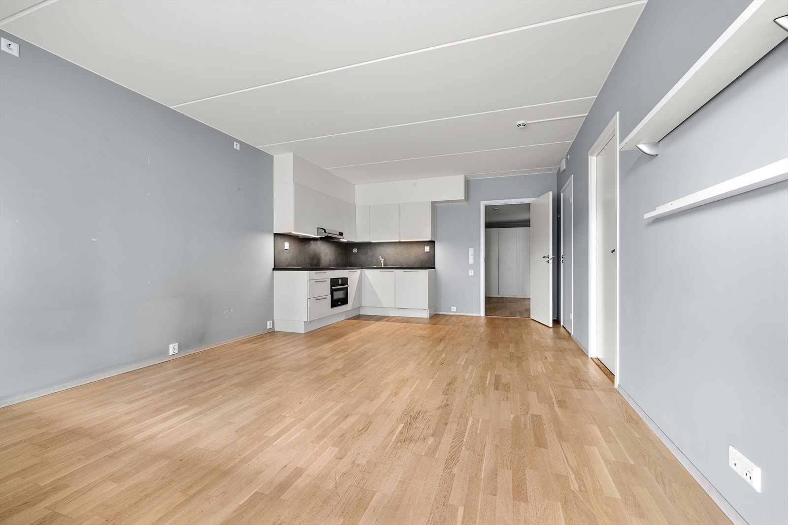 Åpen løsning mellom stue og kjøkken skaper en sosial og innbydende atmosfære. Galleribilde