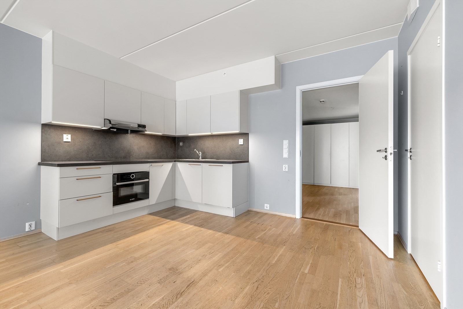 Kjøkkenet har laminatbenkeplate og glatte fronter for et helhetlig uttrykk. Galleribilde