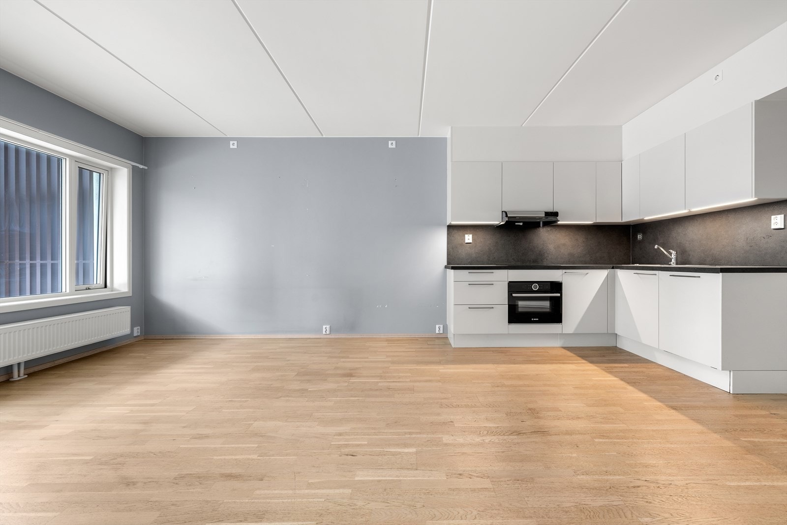 Stilren kjøkkeninnredning som er elegant integrert i allrommet. Galleribilde