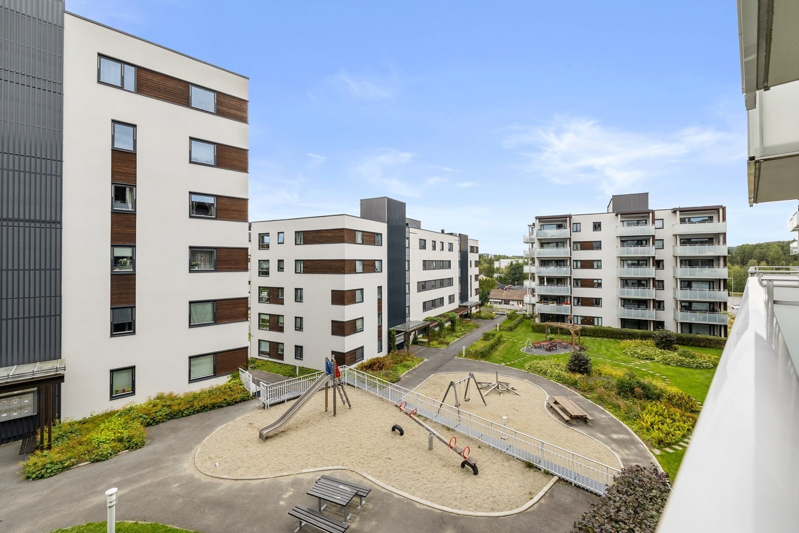 Hyggelig og barnevennlig gårdsrom med lekeapparater, trygt plassert mellom byggene. Galleribilde