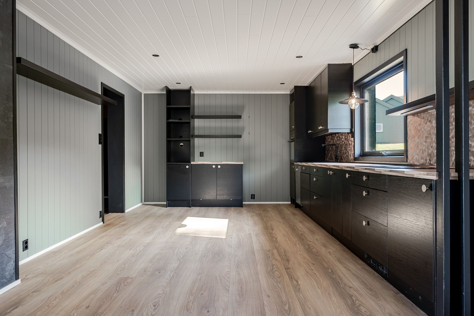 Kjøkkenet har mye skapplass og benkeplass. Galleribilde