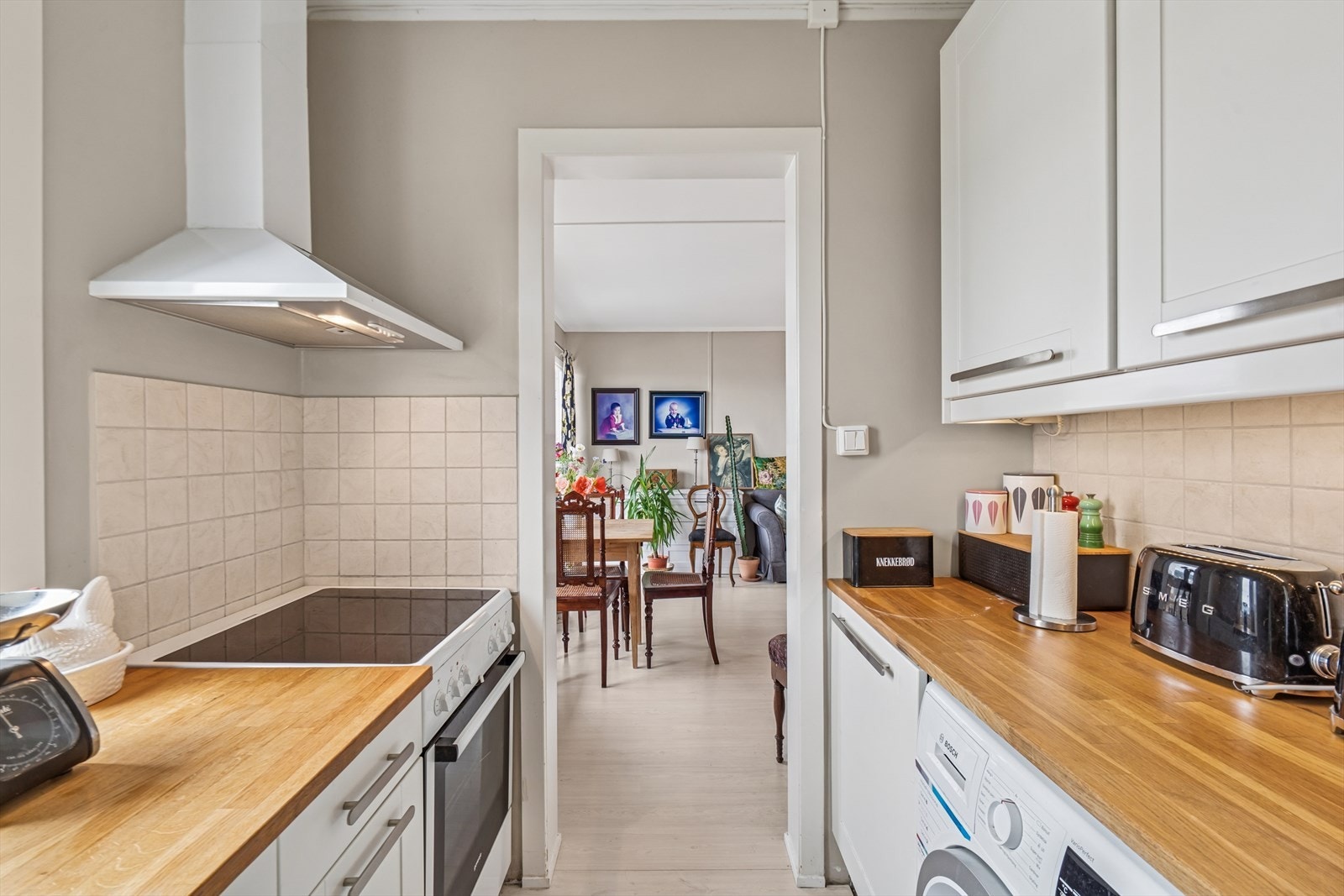 Kjøkkenet er innredet med hvite profilerte fronter og heltre benkeplate. Galleribilde