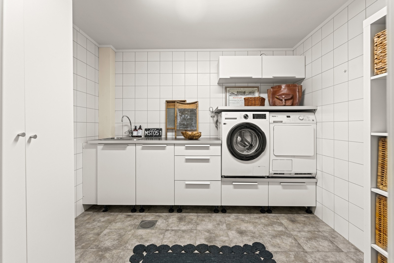 Praktisk, separat vaskerom med rikelig innredning med skuffer, skap og arbeidsbenk i laminat og nedfelt kum Galleribilde