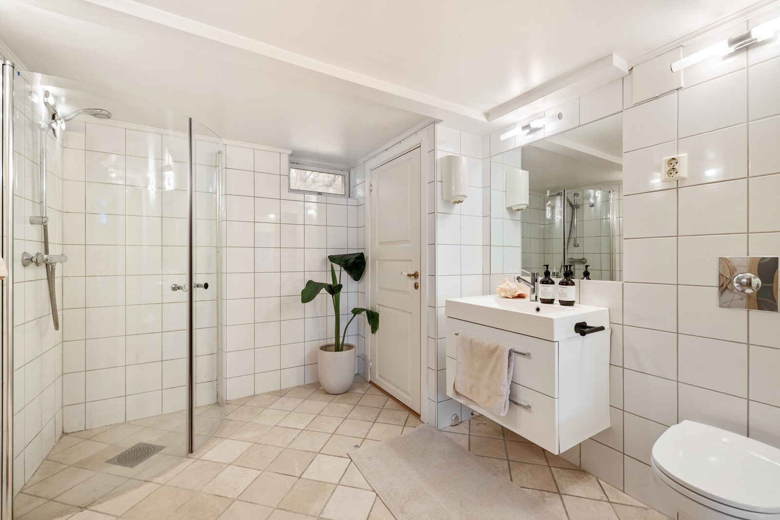 Stort, flislagt bad med pen innredning. Galleribilde