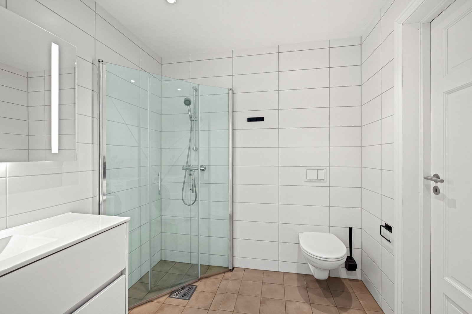 Første etasje har et praktisk, flislagt bad med dusjhjørne og vegghengt toalett. Opplegg for vaskemaskin. Galleribilde