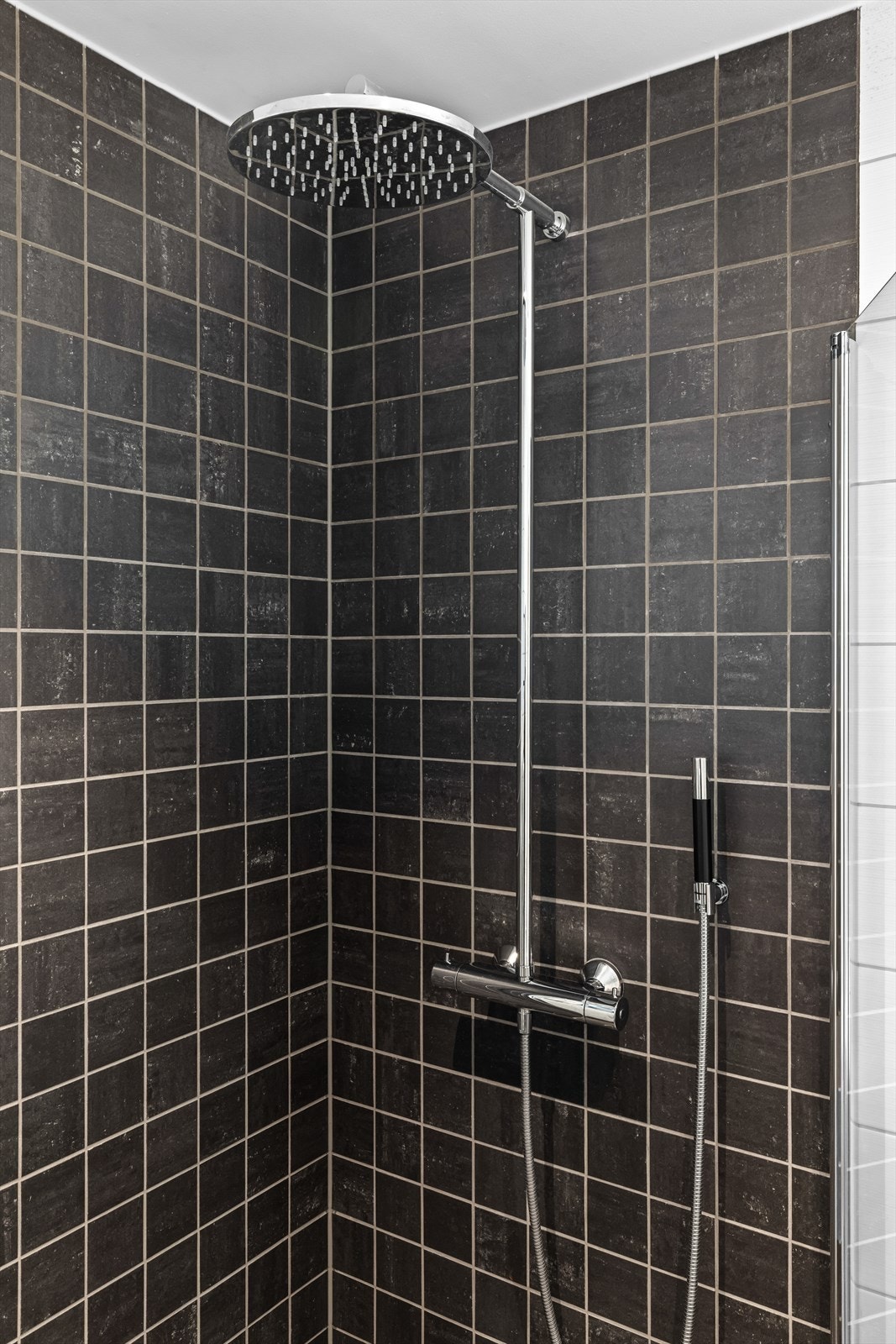 Dusjsonen har innfellbare vegger i herdet glass og en regnfallsdusj. Galleribilde