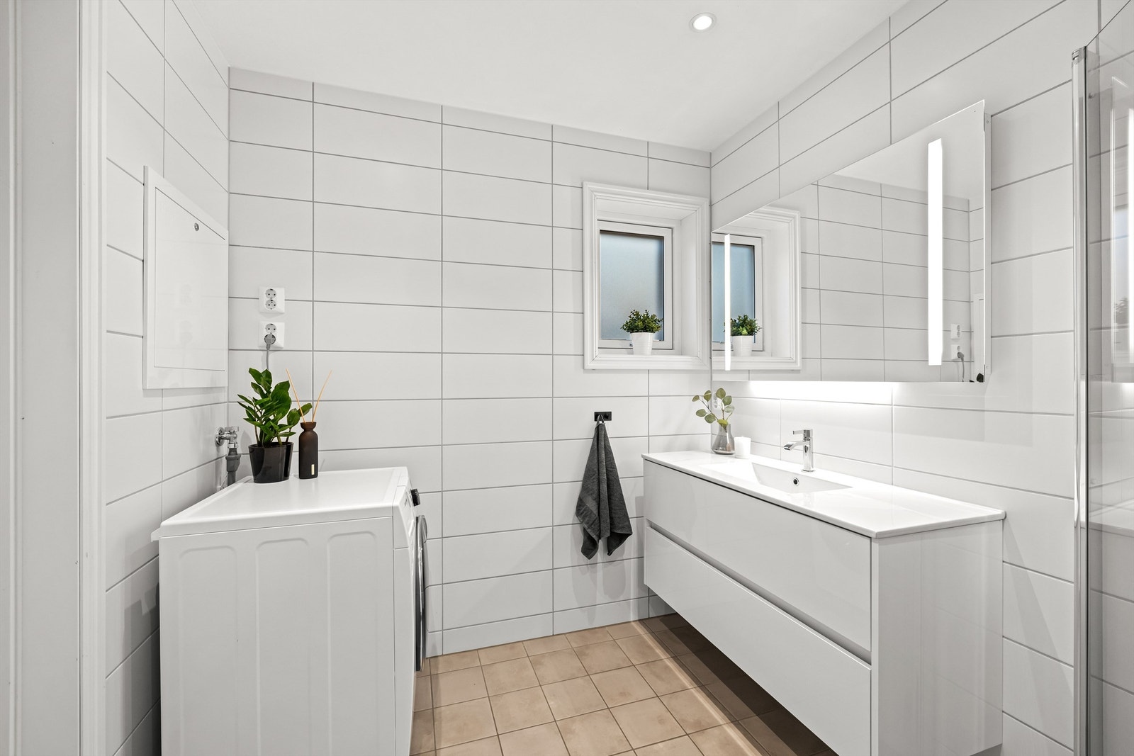 Baderomsinnredningen har heldekkende servant og speil med integrert belysning. Galleribilde