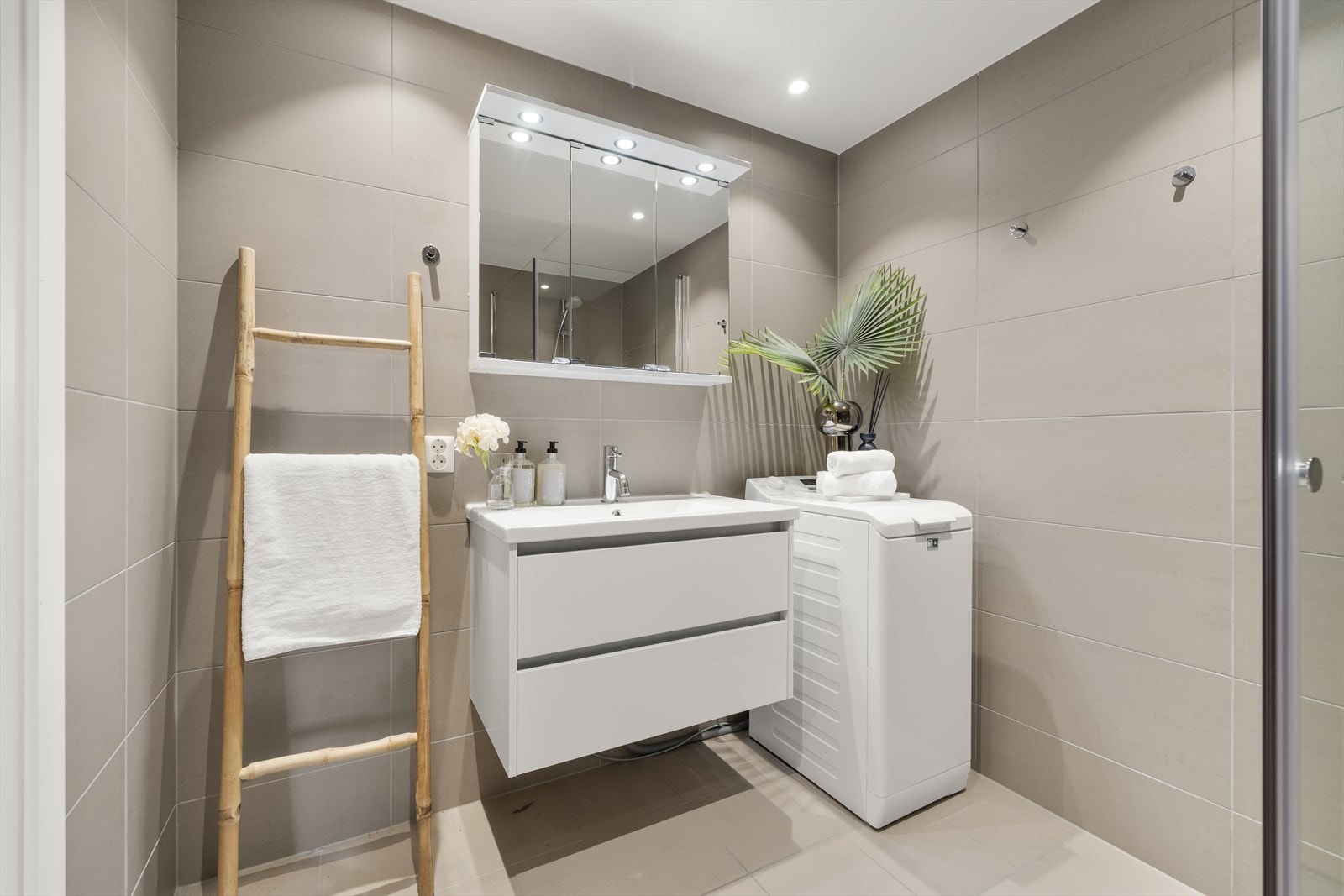 Innredningen består av vegghengt toalett, dusjnisje med glassvegger og opplegg for vaskemaskin. Galleribilde