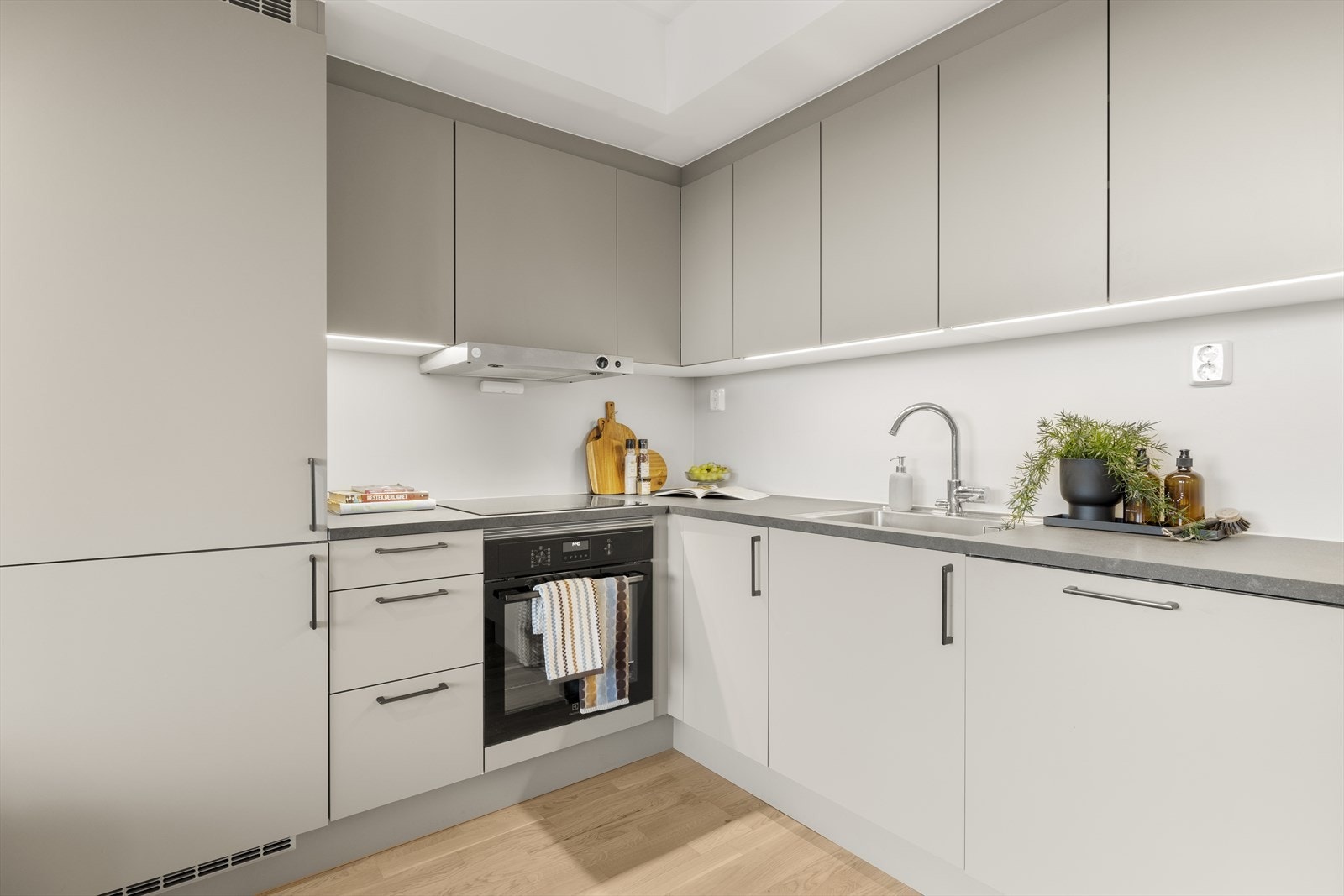 Detaljer som nedfelt oppvaskkum i stål og rikelig med skapplass bidrar til et funksjonelt kjøkken. Galleribilde