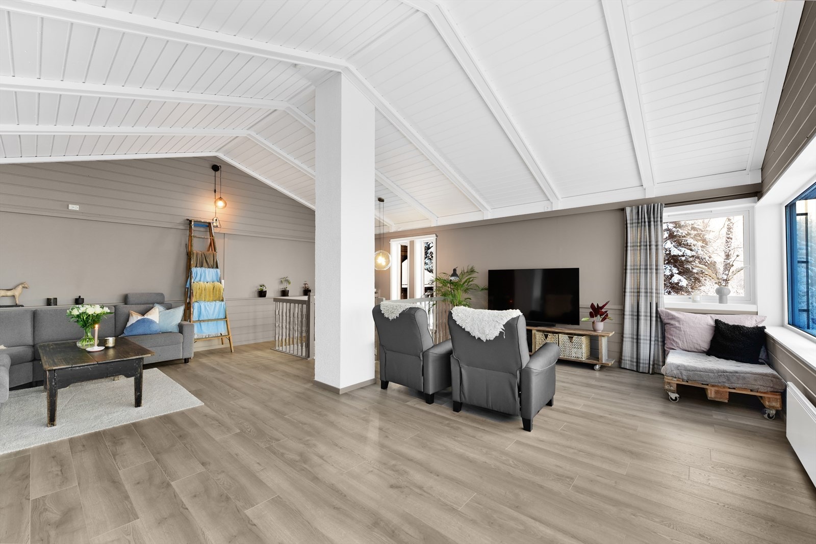 Stuen er romslig og har en luftig atmosfære med åpen himling og store vinduer i utsiktsretningen Galleribilde