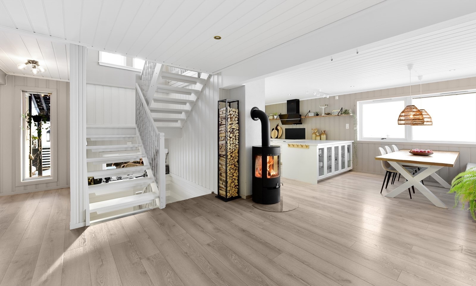 Fra entreen åpner boligen seg opp mot et sosialt allrom med stue og kjøkken - vedovnen er fra 2022 Galleribilde