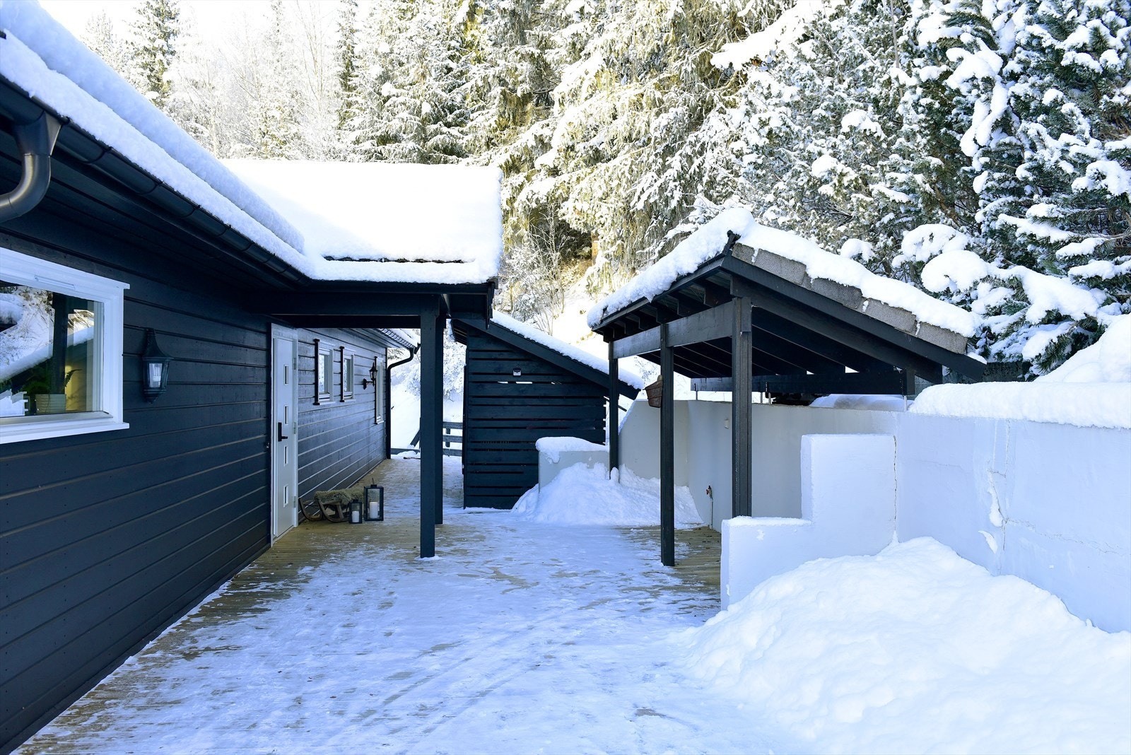Stor terrasseplatting på to av boligens sider. Overbygde passasjer gir ly for vær og vind mellom bygningsdelene. Galleribilde