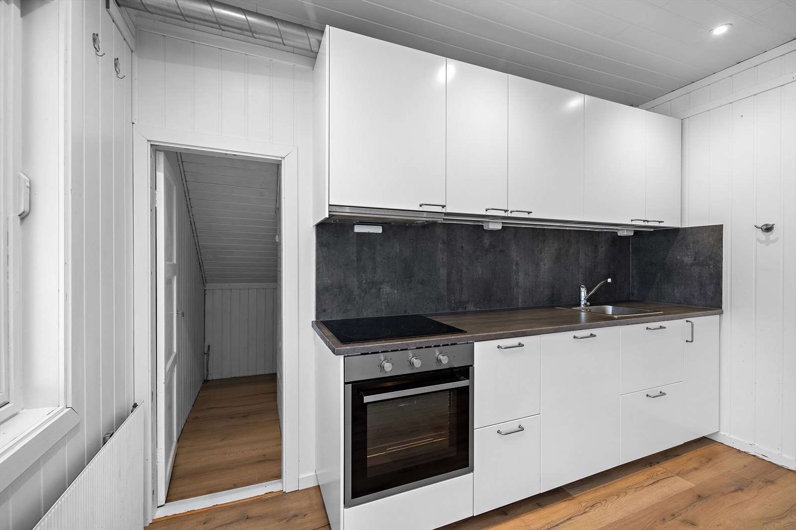 Kjøkkeninnredningen er stilren med slette fronter og integrert stekeovn. Galleribilde