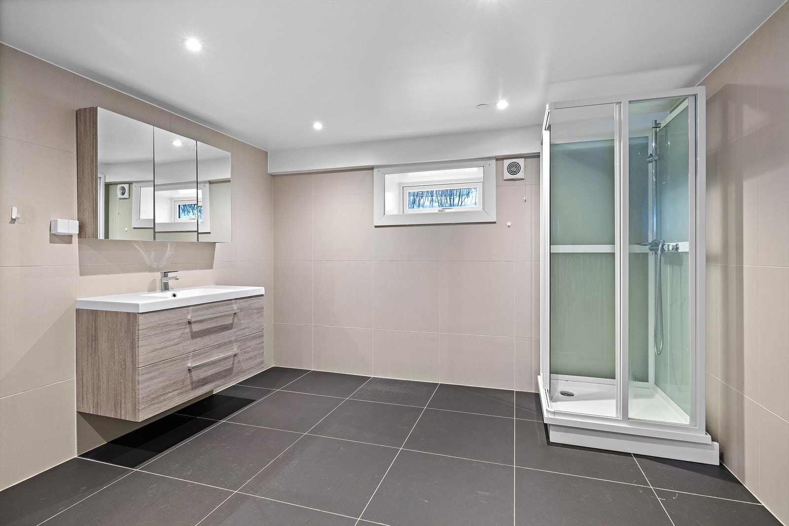 Badet er utstyrt med dusjkabinett og servant med god oppbevaringsplass. Galleribilde